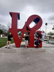 Quatre élèves posnet pour une photo devant une enseigne "LOVE"